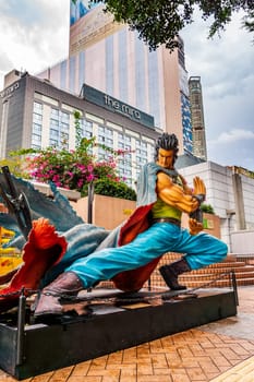 Hong Kong, China, March 2013 Statues of famous characters, in Hong Kong Avenue of Comic Stars, Kowloon Park. Urban skyline background of Tsim Sha Tsui District