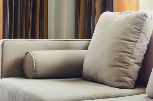 Fabric sofa with cushions in living room and natural soft window light