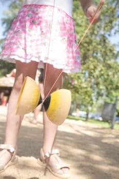 Little girl learning to use diabolo in the park. Classic games for children concept