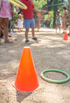 Children throwing colorful ring to cone in the park. Classic games for children concept