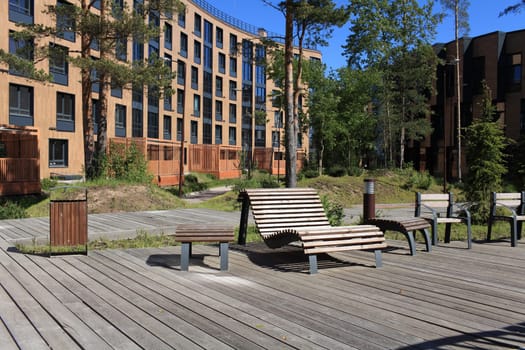 wooden boardwalk in front of the apartment, bench in the foreground