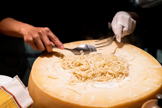 Chef cooking pasta in cheese bowl