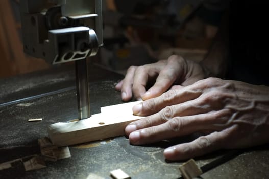 Carpenter builder working with electric jigsaw and wood. Woodworker cutting a piece of wood