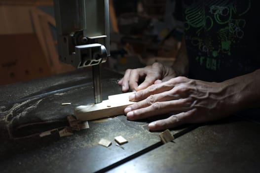 Carpenter builder working with electric jigsaw and wood. Woodworker cutting a piece of wood