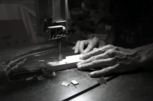 Carpenter builder working with electric jigsaw and wood. Woodworker cutting a piece of wood