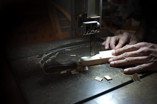 Carpenter builder working with electric jigsaw and wood. Woodworker cutting a piece of wood