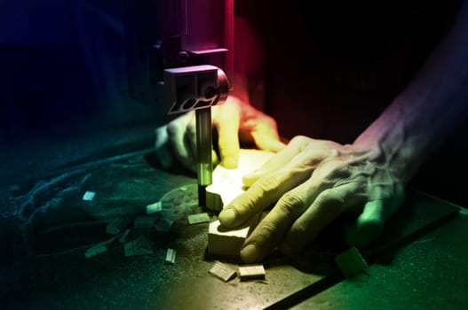 Carpenter builder working with electric jigsaw and wood. Woodworker cutting a piece of wood