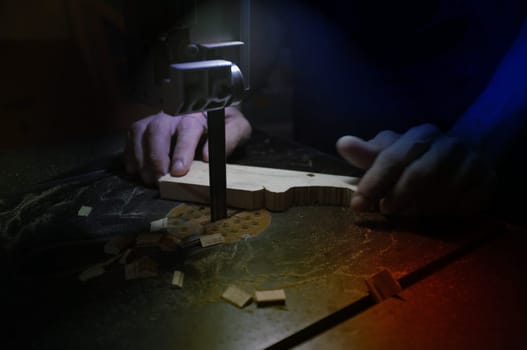 Carpenter builder working with electric jigsaw and wood. Woodworker cutting a piece of wood