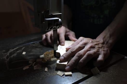Carpenter builder working with electric jigsaw and wood. Woodworker cutting a piece of wood