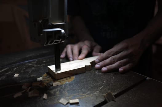 Carpenter builder working with electric jigsaw and wood. Woodworker cutting a piece of wood