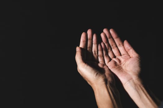 Hand of man while praying for religion. Concept peace and life.