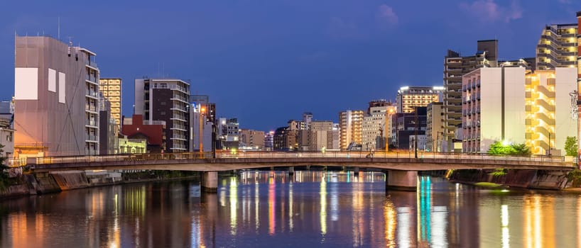 Panorama Fukuoka old town along naka river at Nakasukawabata sunset twilight. This area is favorite for tourist for Fukuoka Yatai, street Food stall,  for hangout at night.
