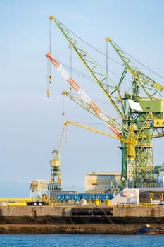 Hoisting cranes in the industrial zone of the Port in Kobe Hyogo Kansai Japan using for import export shipping and global business background