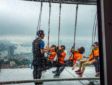 Macau, China, March 2013: Group of people on Sky Walk at Macau Tower in rainy day, popular extreme sport attraction and adrenaline rush activity