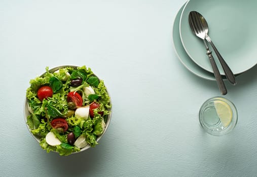 Healthy green salad with tomato and mozzarella cheese. Home made food. Concept for a tasty and healthy meal