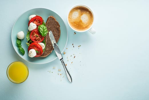Delicious healthy breakfast with tomato and mozzarella sandwich, coffee and juice. Concept for healthy food