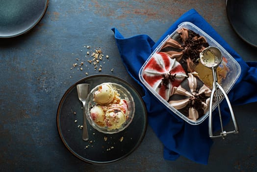 Mixed ice cream scoops, scooped out of a container with a utensil