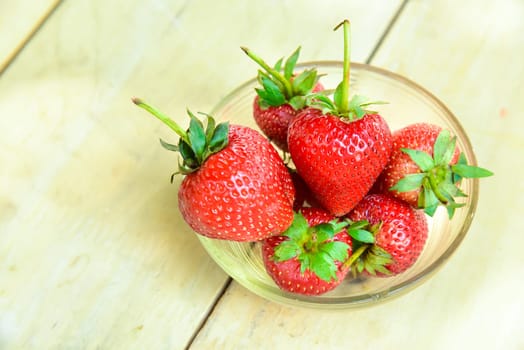 Fresh strawberries in a bowl on bamboo background