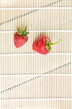 Fresh strawberries in a bowl on bamboo background