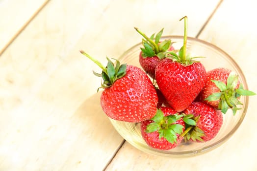 Fresh strawberries in a bowl on bamboo background