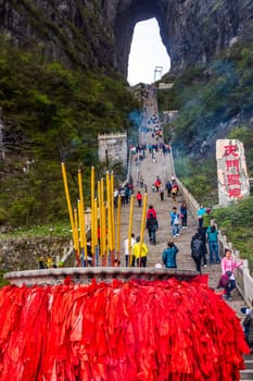 Zhangjiajie, Hunan, China Apr 2013 Incense pot on the bottom platform and tourists climbing 999 stairs to Haven Gate in Tianman Mountains