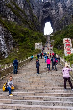 Zhangjiajie, Hunan, China Apr 2013 Tourists climbing 999 stairs to Haven Gate in Tianman Mountains. View from bottom platform on climbing people below