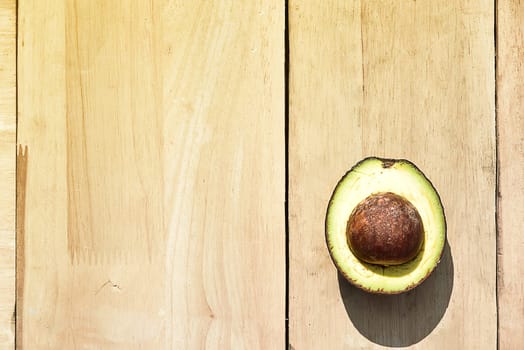 Half avocado on wooden board