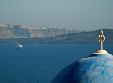 View of Santorini caldera with typical Cyclades church dome and distant ship
