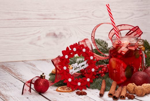 Winter holidays still life with fir tree branch, fruit tea, spices, nuts and oranges on a light wooden background with copy space. New Year and Christmas. Winter vacation.