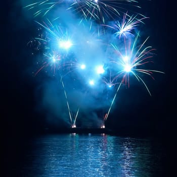 Blue colorful fireworks on the black sky background. Holiday celebration.