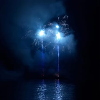 Blue colorful fireworks on the black sky background. Holiday celebration.