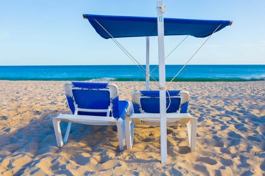 Beach chair with awning structure for sunshade. Beach background