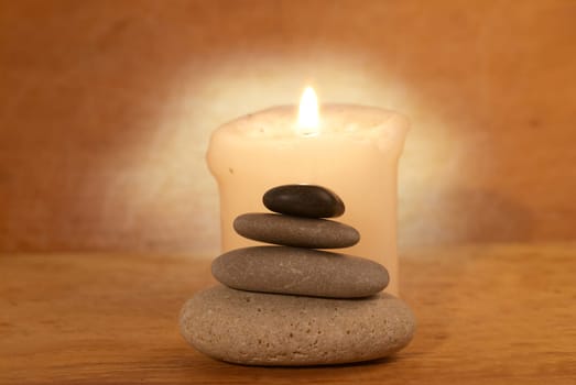 Spa concept with candle, zen stones and wooden background