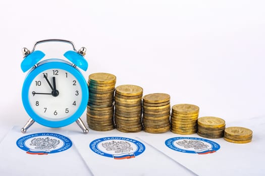 Anapa, Russia - September 3, 2019: Tax notifications, clocks and rising stacks of coins