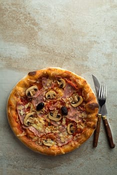 Pizza served with mozzarella cheese, ham, mushrooms and tomato sauce