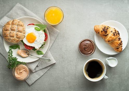 Breakfast served with orange juice, sandwich with egg, croissants and coffee. Delicious healthy breakfast.