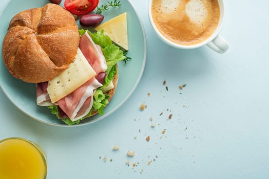 Breakfast served with coffee, juice, sandwich with ham, cheese, tomato and lettuce. Continental delicious healthy breakfast table