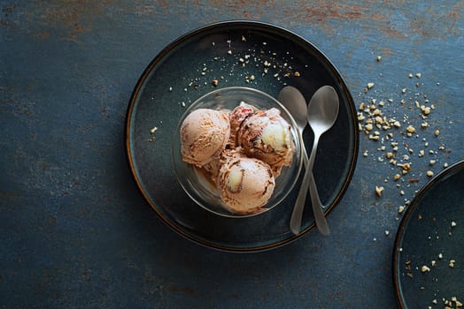 Homemade Organic Ice cream scoops with chocolate and nuts in a plate close up