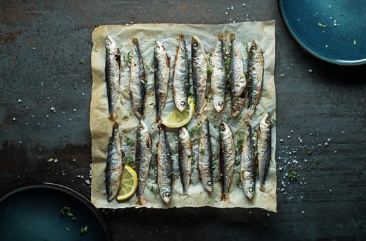 Grilled sardines with lemon and herbs close up. Healthy vegetarian fish meal