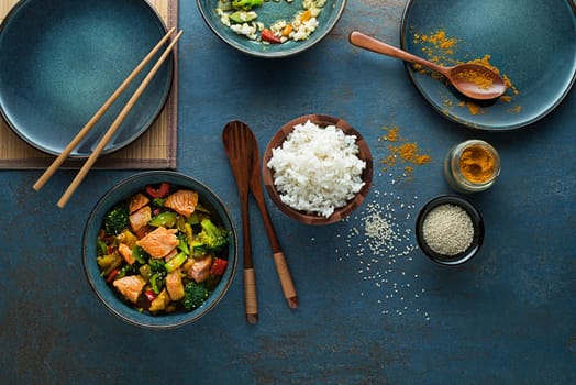 Eating Chinese food with rice, salmon and vegetables