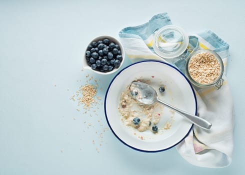 Eating porridge oatmeal with fruits, berries, and honey. Concept of healthy breakfast, wellbeing, healthy eating, dieting and weight loss