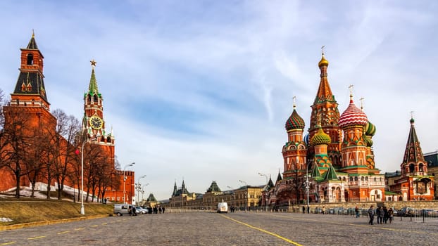 Moscow, Russia, April 2013 Tourists visiting St Basils Cathedral, Beautiful Spasskaya Tower and The Tsars Tower on the Red Square at beautiful sunrise