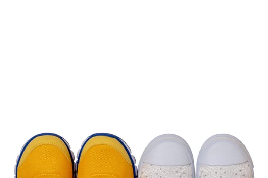 Top view on details of two colorful pairs shoes isolated on a white background. Sneaker fashion for kids. Space for design.