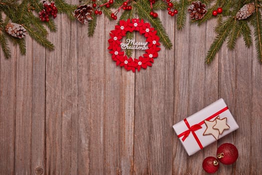Wooden vintage background with fir tree branches, gift box and Christmas ornaments. Top view with copy space. New Year and Christmas, For greeting card or advertising