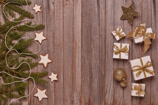 Wooden vintage background with fir tree branches, gift boxes and Christmas ornaments. Top view with copy space. New Year and Christmas, For greeting card or advertising