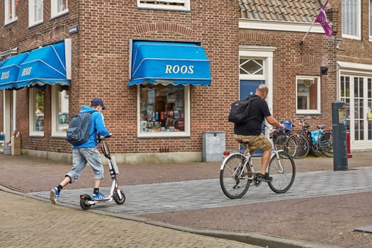 VLISSINGEN, NETHERLANDS - JUNE 15, 2017: People using bicycles as a traditional way of transportation through streets of town of Vlissingen in Netherlands.