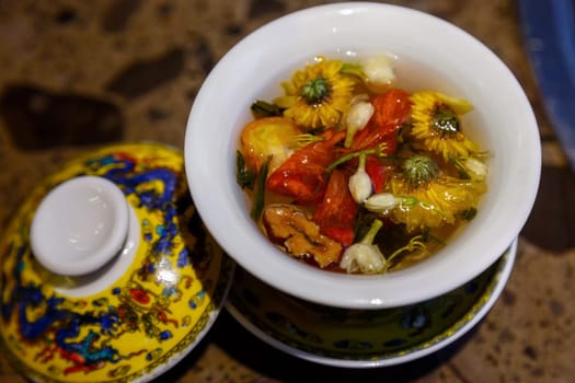 Flower tea in a closing Chinese cup on a table in a cafe