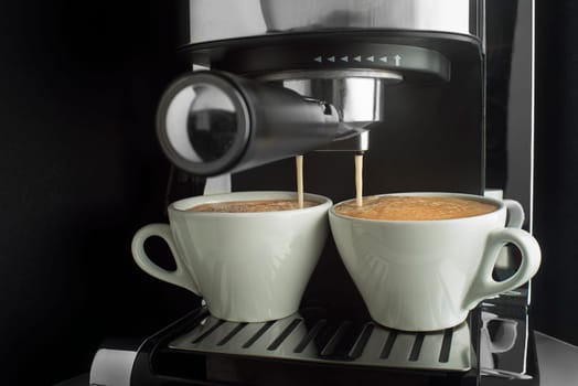 Espresso coffee pouring from coffee machine. Professional coffee brewing