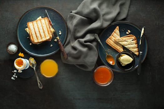 Breakfast served with orange juice, toast sendwich, boiled egg, jam and butter. Delicious healthy breakfast.