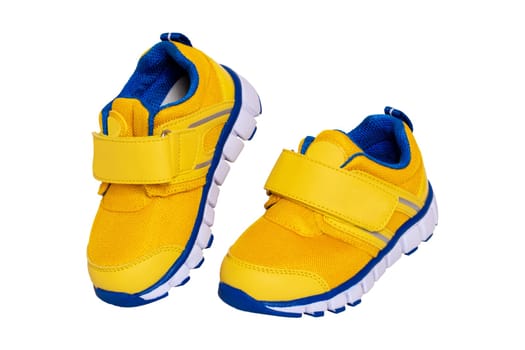 Child shoe fashion. Close-up of a pair of yellow blue child sneaker or sport shoes isolated on a white background. Elegant and trendy shoes for girls. Macro.